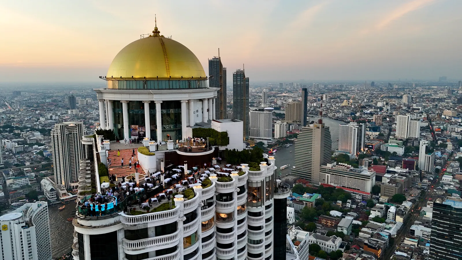 The golden dome of Sky Bar at lebua above the Chao Phraya and the Bangkok skyline at dusk