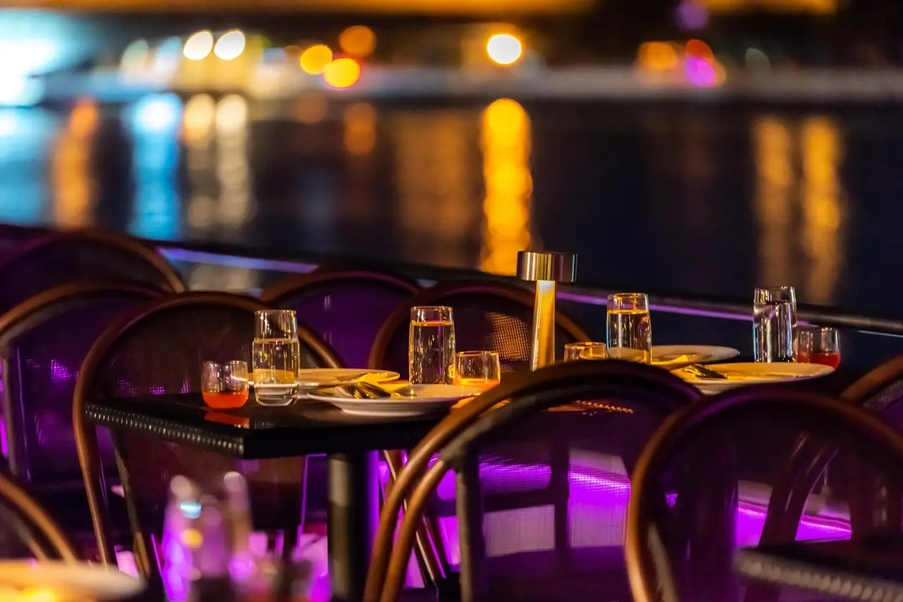 A table for two on the rooftop deck, river lights behind