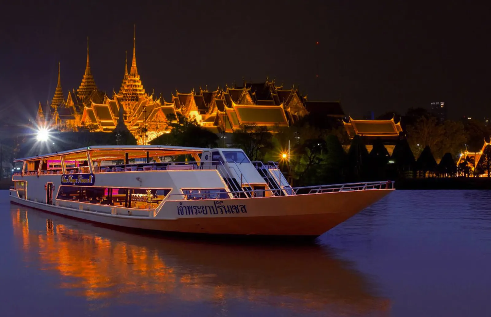 The Chao Phraya Princess sailing past the lit-up Grand Palace at night