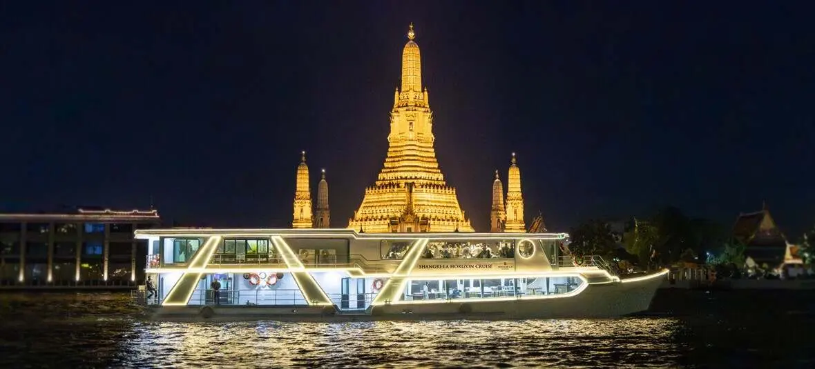 The Shangri-La Horizon Cruise lit up on the river at night, in front of Wat Arun