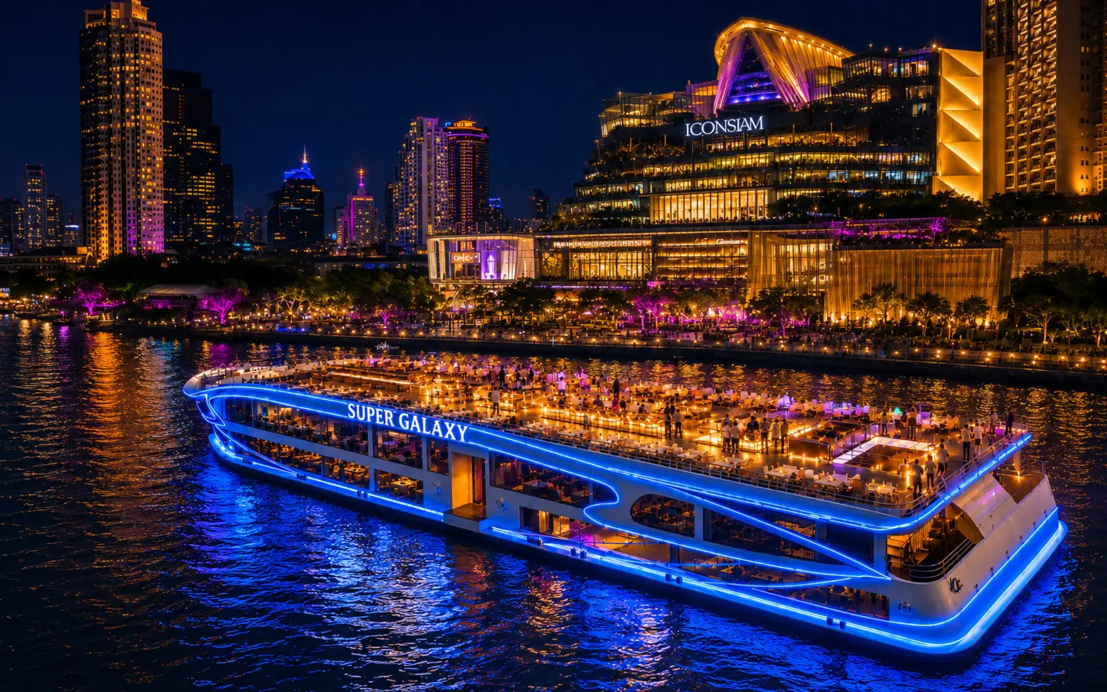 The Super Galaxy cruise boat lit up in blue on the Chao Phraya at night, in front of ICONSIAM