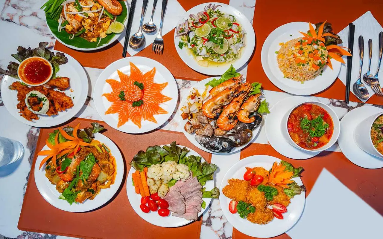 Plates from The Planet Cruise buffet: salmon sashimi, grilled prawns, pad Thai and curries