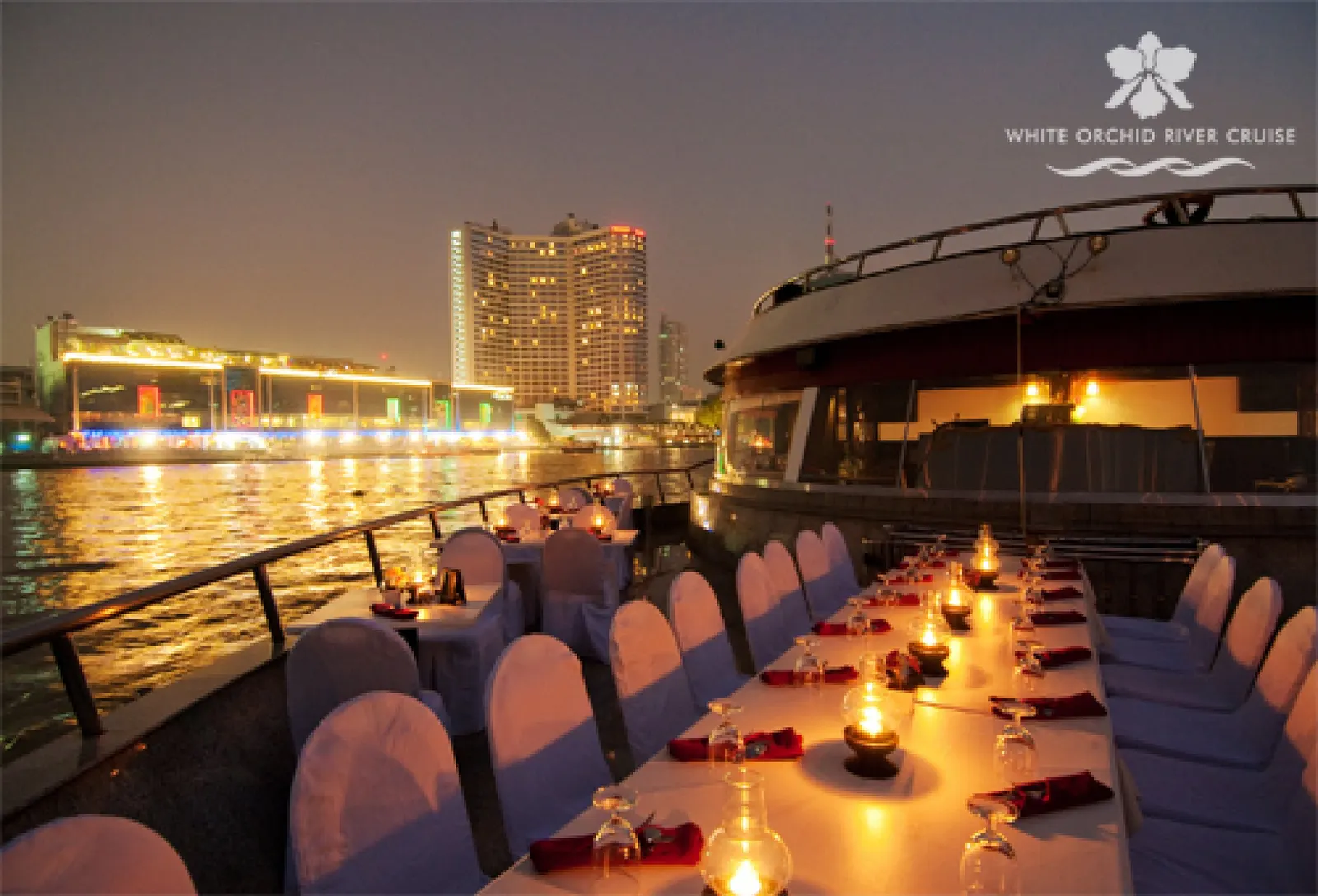 Candlelit tables on the open deck of the White Orchid at dusk