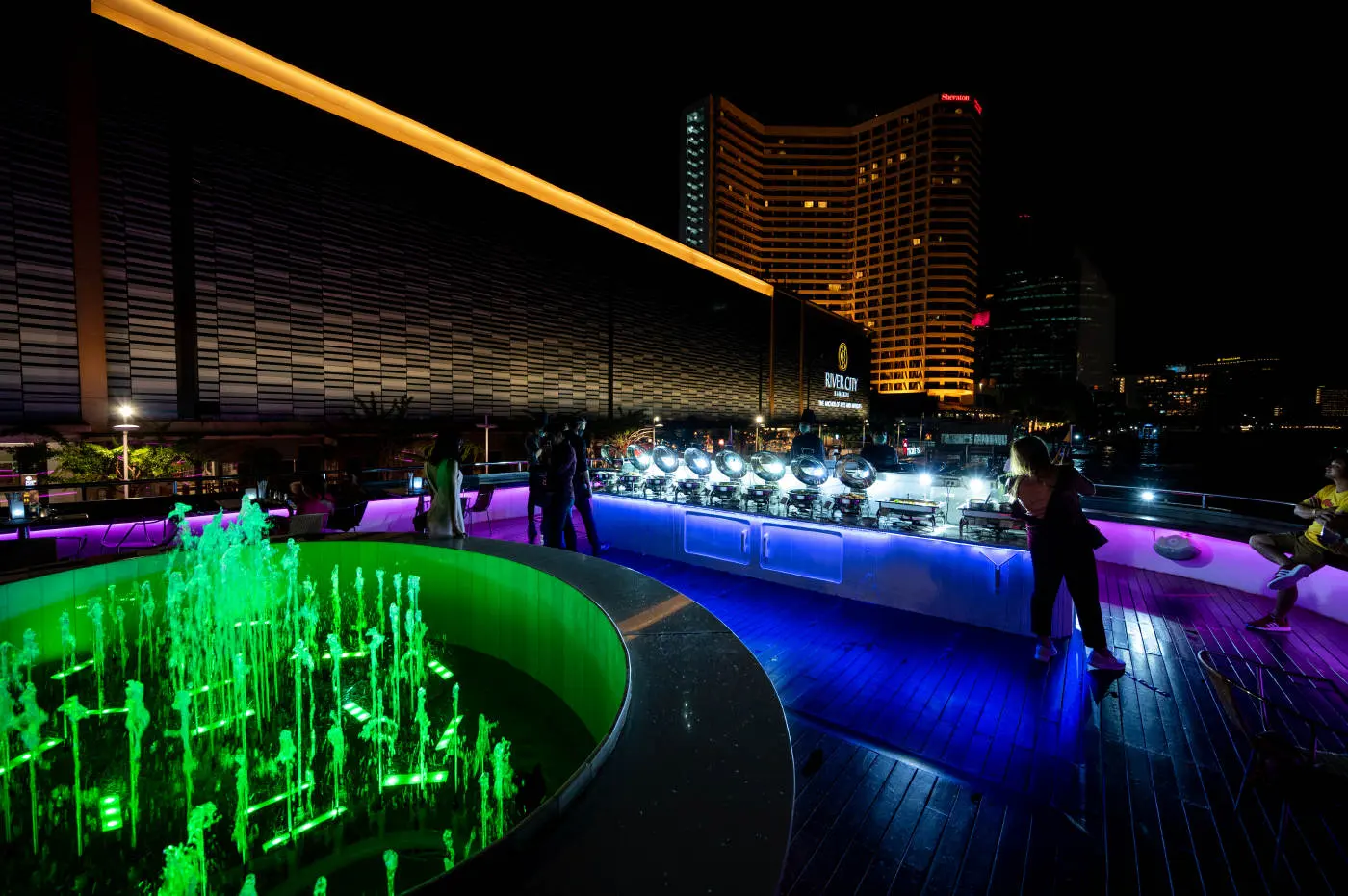 The lit fountain and buffet on the rooftop deck of Wonderful Pearl, moored at River City