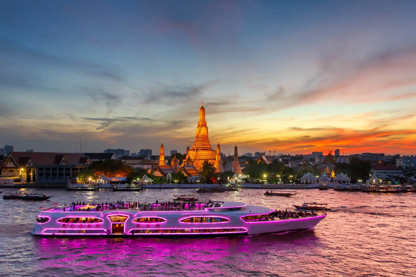 Wonderful Pearl lit up in pink on the river at dusk, in front of Wat Arun