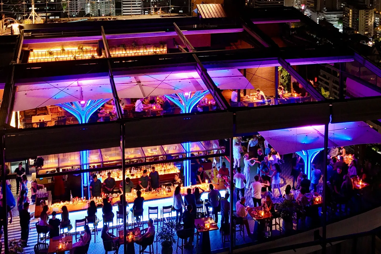 Above Eleven rooftop bar lit blue and purple at night above Sukhumvit, Bangkok