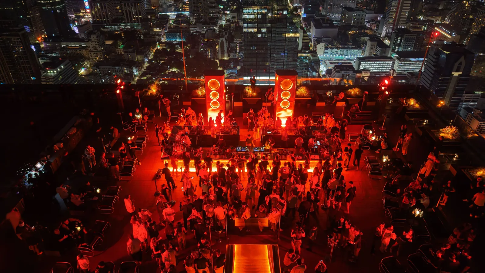 Night view of Aether rooftop bar's glowing oval lounge, 44 floors above Silom, Bangkok