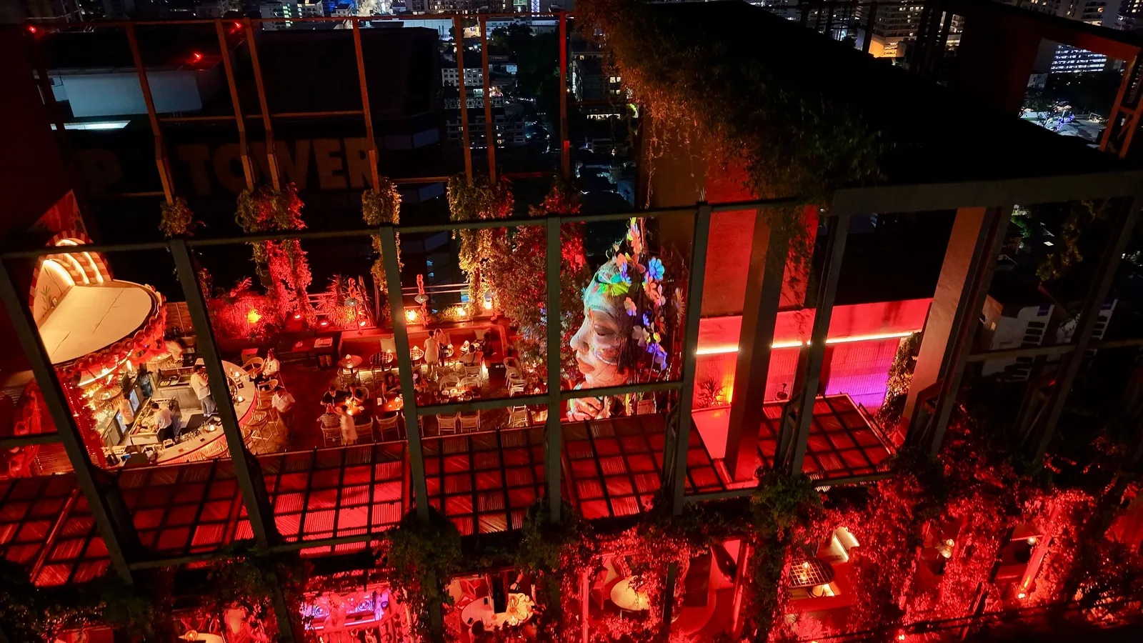 Tulum SkyBar's lush, neon-lit party deck at night on the 29th floor of Estella Ekkamai, Bangkok