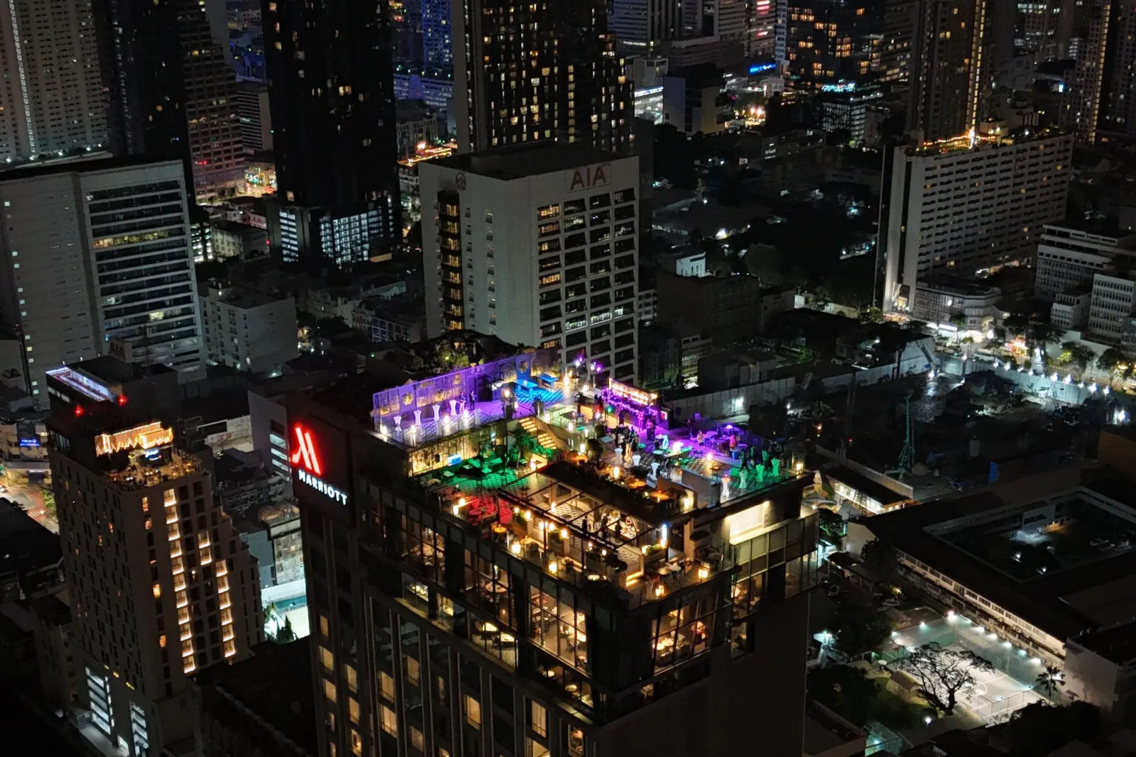 Yao Rooftop Bar lit up at night atop the Bangkok Marriott Hotel The Surawongse, with the Bangkok skyline behind