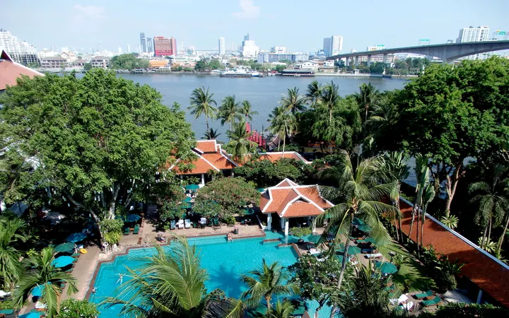 The pool and gardens of Anantara Riverside Bangkok Resort, with the Chao Phraya behind