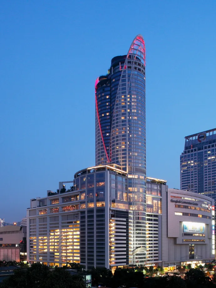 The Centara Grand at CentralWorld tower against a clear evening sky, CentralWorld at its foot