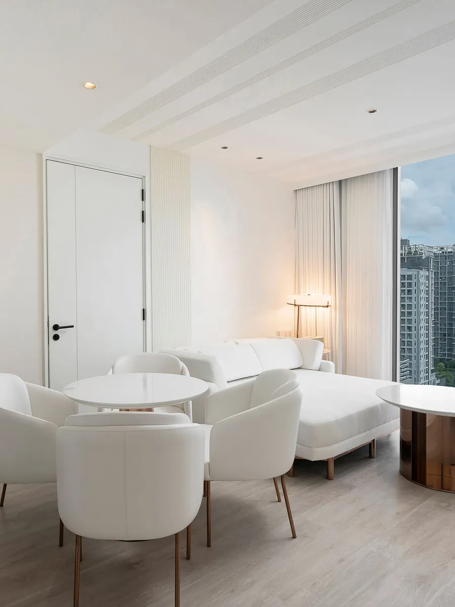 The living room of a Townhouse suite at INNSiDE by Meliá Bangkok Sukhumvit, white armchairs by the window