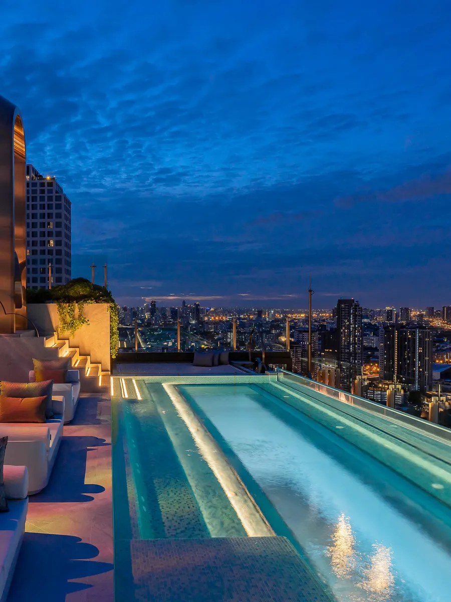The 34th-floor infinity pool and lounge terrace of INNSiDE by Meliá Bangkok Sukhumvit at blue hour