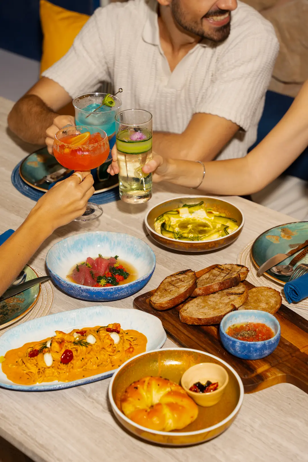 Friends toasting over a spread of shared Mediterranean plates at View rooftop, Bangkok
