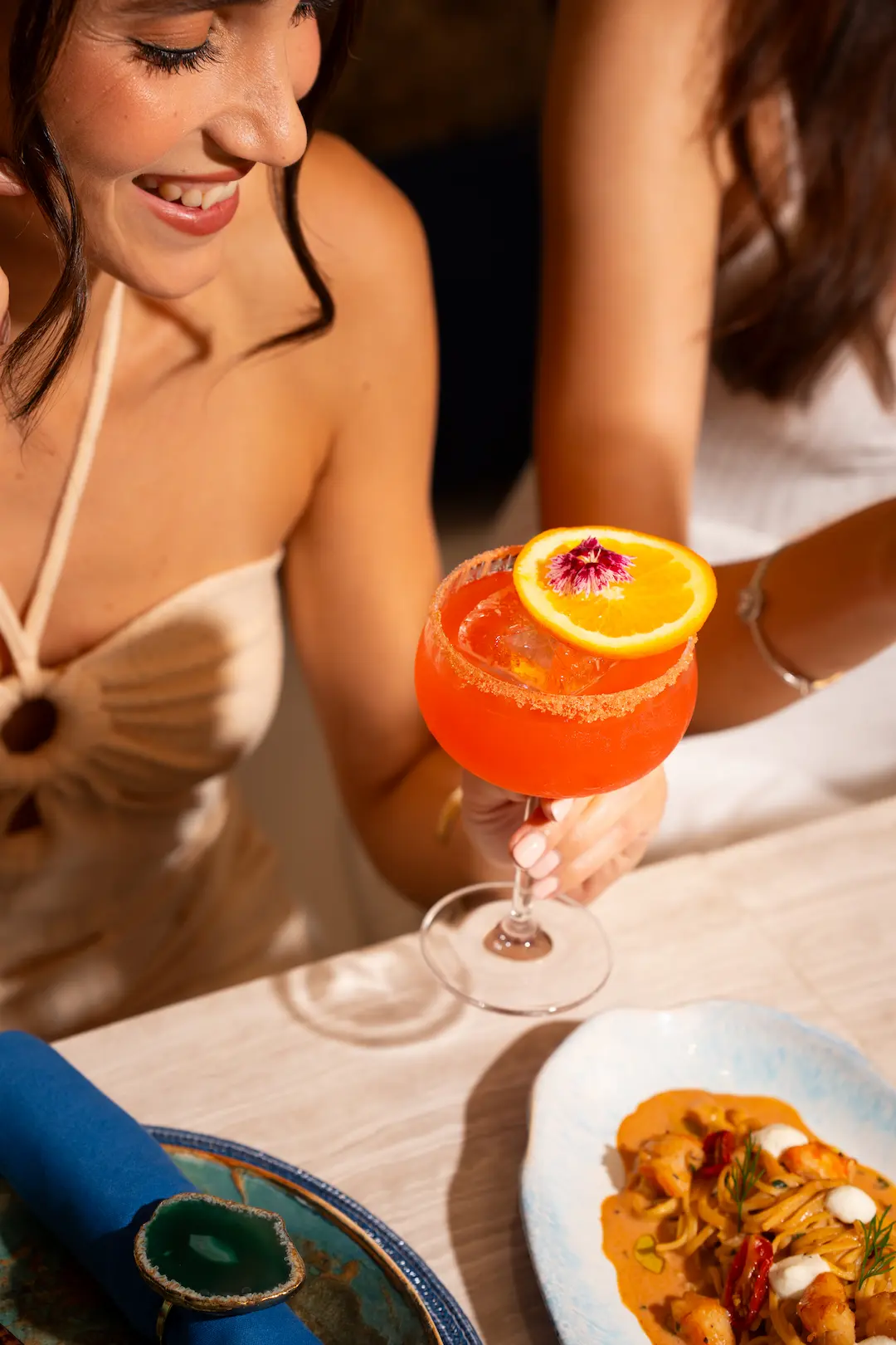 View rooftop's signature orange cocktail garnished with orange and an edible flower, Bangkok